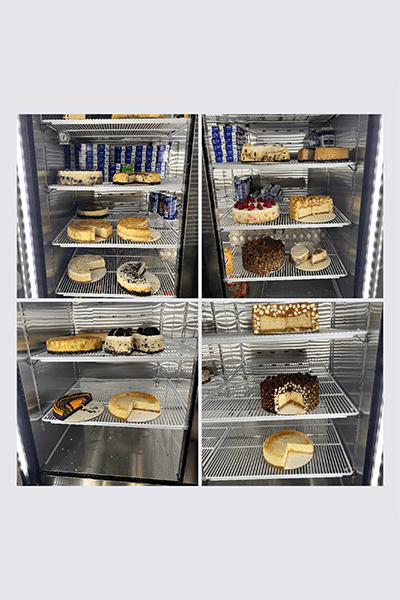 A variety of cakes in refrigerators and trays.
