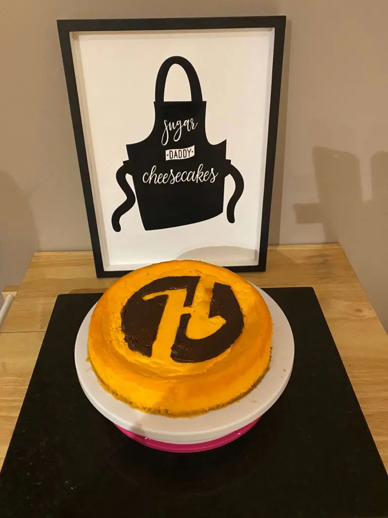 A cake sitting on top of a table next to an apron.