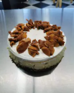 A cake with white frosting and nuts on top.