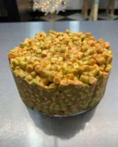 A cake with corn on top of it sitting on a table.